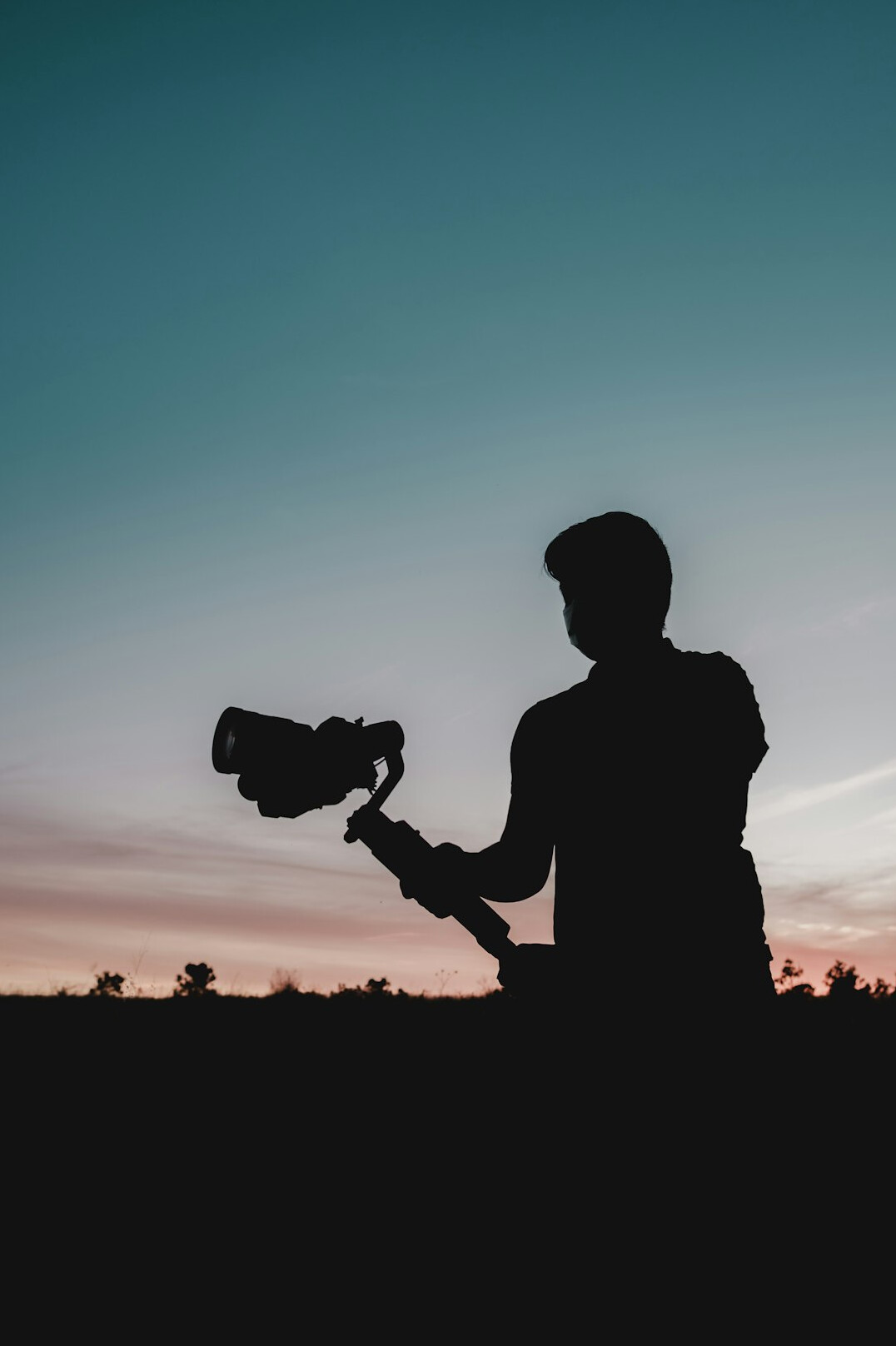 Camera operator filming with a professional broadcast pedestal camera in a TV studio
