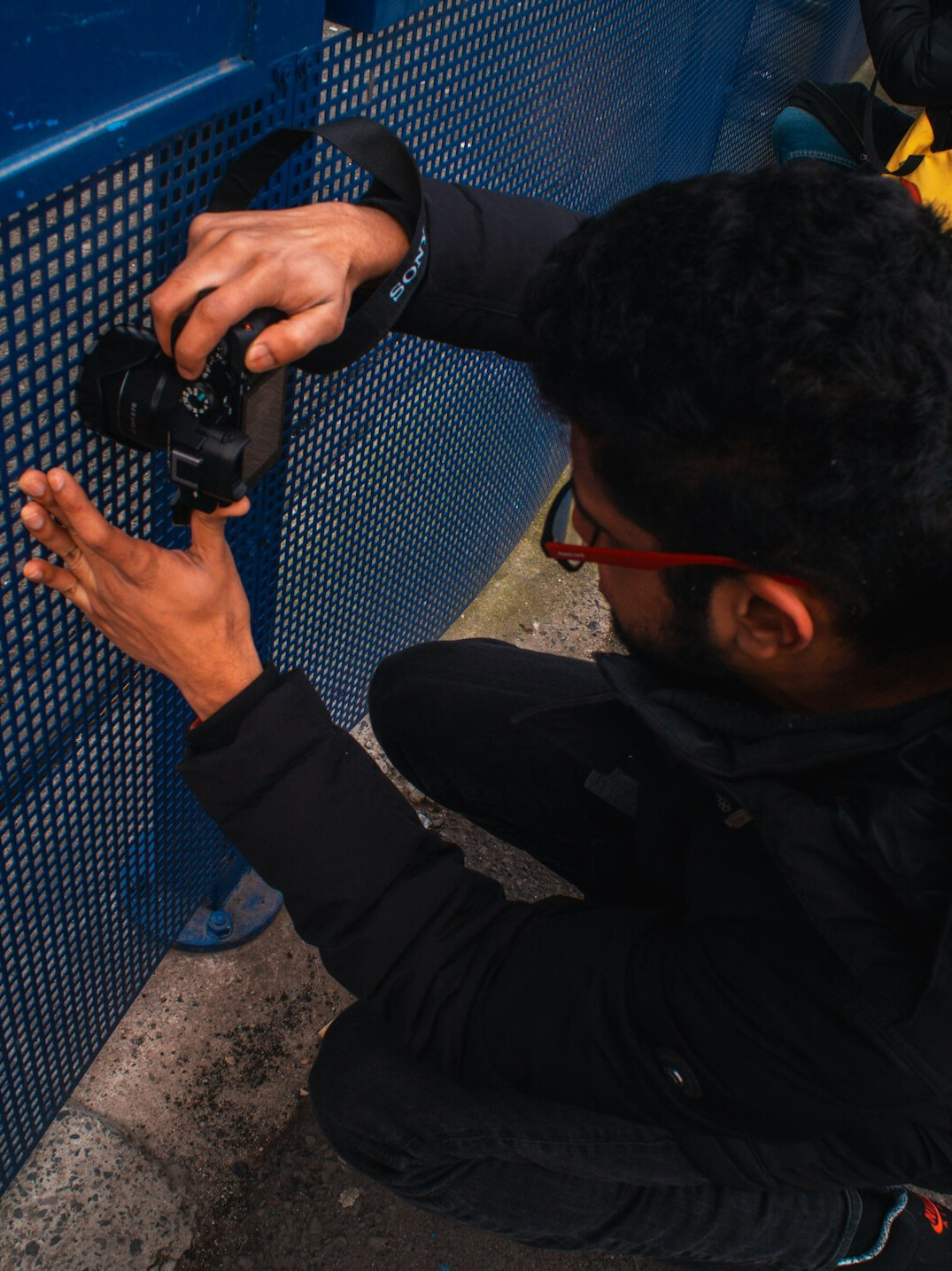 Technician adjusting a camera pedestal head on a television studio floor